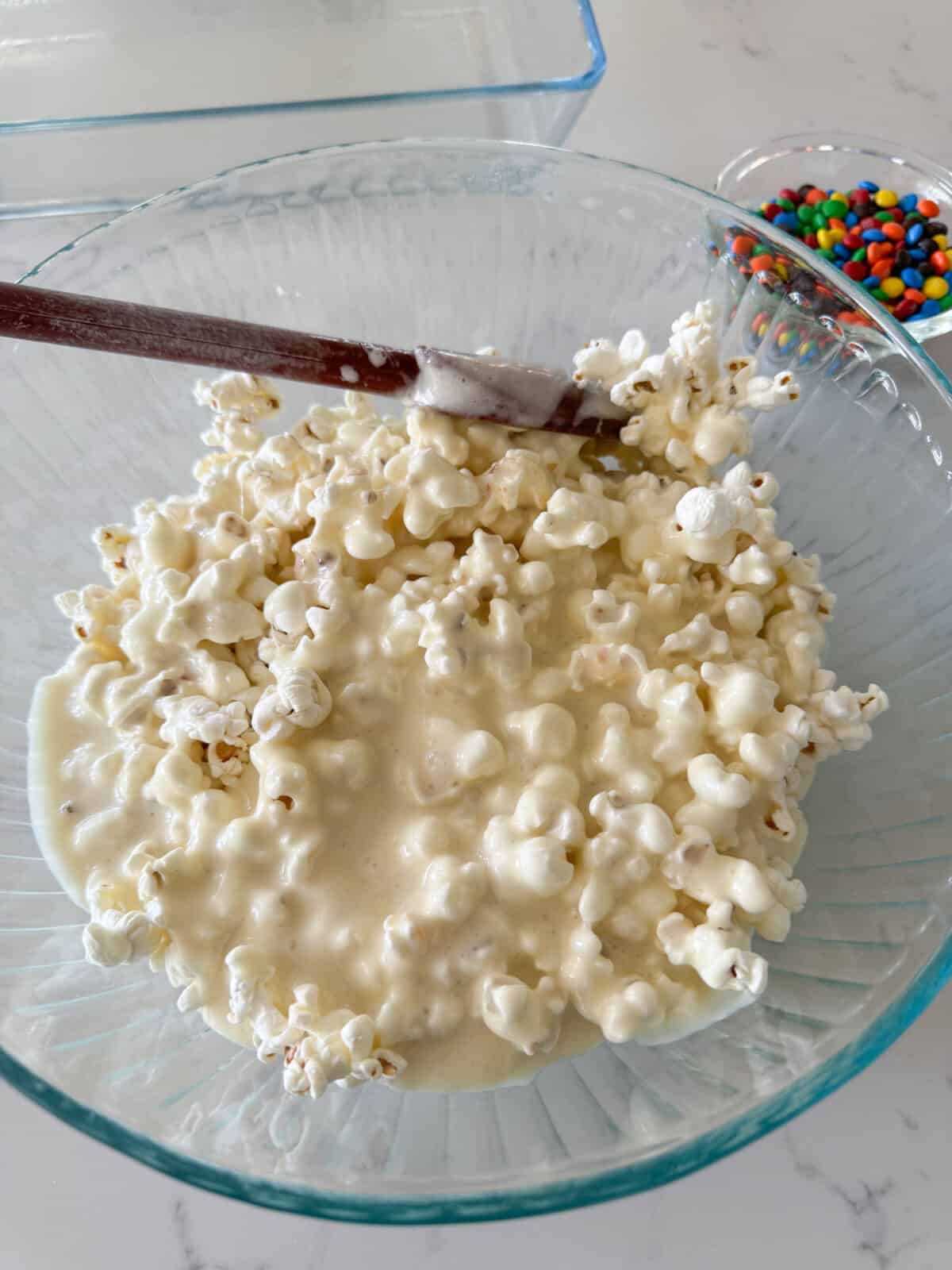 melted marshmallows added to bowl of popcorn and cereal